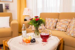 Zimmerdetail mit frischen Blumen, Obst und Saftkrug